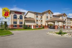 a hotel with a sign in front of it at Super 8 by Wyndham Fort St. John BC in Fort Saint John