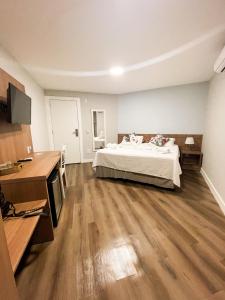 a large bedroom with a bed and wooden floors at Athos Hotel in Teresópolis