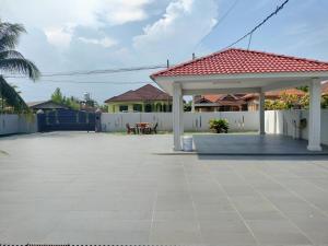 a patio with a pavilion with a table and a fence at RINA HOMESTAY Kemaman in Cukai