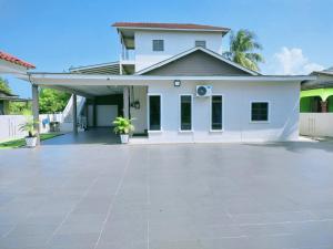 a large white house with a large driveway at RINA HOMESTAY Kemaman in Cukai