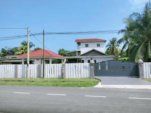 a white fence in front of a white house at RINA HOMESTAY Kemaman in Cukai