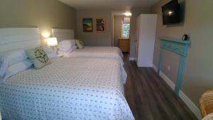 a small bedroom with two beds and a television at North Rustico Harbour Inn in North Rustico