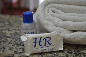 Eine Flasche ihrer Flüssigkeit steht neben einem Handtuch. in der Unterkunft Hotel Rafeli in Boituva