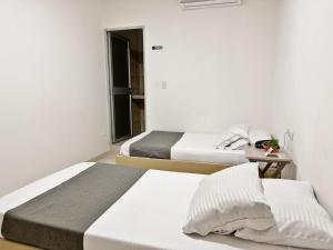 a bedroom with two beds and a table at Hotel Boutique Gao in Cúcuta