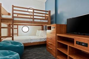 um pequeno quarto com um beliche e uma televisão em Holiday Inn Express & Suites Orlando- Lake Buena Vista, an IHG Hotel em Orlando