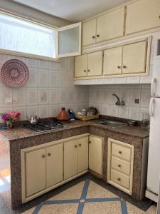 a kitchen with white cabinets and a sink at Surf Therapy in Agadir