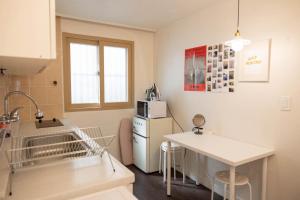 a kitchen with a white refrigerator and a table at Chuls lodge in Seoul