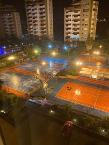 einen Tennisplatz mit Lichtern in einer Stadt in der Nacht in der Unterkunft Departamento 4 habitaciones 12 personas vista al mar 8vo piso Playa Almendro in Tonsupa