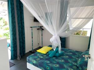 a bedroom with a bed with a canopy and a window at LE FARE BLEU eco in Tiputa