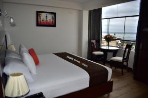 伊洛的住宿－InkaOcean Hotel，一间卧室配有一张床和一张桌子,享有美景