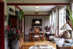 AQUIARES COFFEE FARM CASA HACIENDA LA ESPERANZA في توريالبا: غرفة معيشة مع طاولة وبعض النباتات