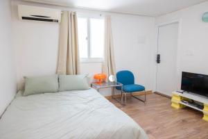 a bedroom with a bed and a blue chair at Chuls lodge in Seoul