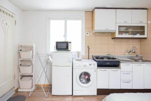 a kitchen with a washing machine and a microwave at Chuls lodge in Seoul