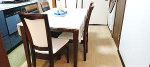 池袋至近完全貸切一軒家 في طوكيو: طاولة طعام مع طاولة بيضاء وكراسي