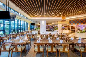 a restaurant with wooden tables and chairs and windows at Crowne Plaza Sanya City Center, an IHG Hotel in Sanya