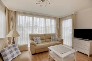 a living room with a couch and a tv at Polderpark 190 in Nieuwpoort