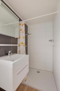 a white bathroom with a sink and a shower at Polderpark 190 in Nieuwpoort