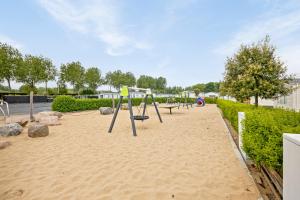 a row of swings in the sand in a park at Polderpark 190 in Nieuwpoort