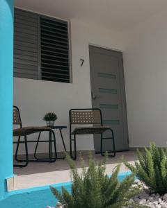 two chairs and a table in front of a door at Villas Boqueyé in Cabo Rojo