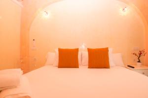 a large white bed with two orange pillows on it at Hostal Palacio Madrid in Madrid