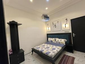 - une chambre avec un lit et une porte noire dans l'établissement Rossoul Appartement, à Cotonou