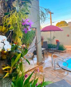 eine Terrasse mit einem Haufen Blumen und einem Regenschirm in der Unterkunft CASA Caldas Novas, Piscina aquecida, Máx 12 pessoas, Locação Mínima de 2 noites in Caldas Novas