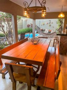 ein Esszimmer mit einem Holztisch und Stühlen in der Unterkunft CASA Caldas Novas, Piscina aquecida, Máx 12 pessoas, Locação Mínima de 2 noites in Caldas Novas