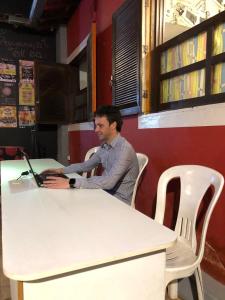 um homem sentado numa mesa usando um computador portátil em Trem Chic em Belo Horizonte