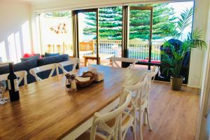 ビクターハーバーにあるVista Victor Harbor Beachfront Apartment No 4の木製のテーブルと椅子のあるダイニングルーム