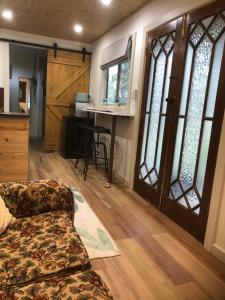 a living room with a couch and an open door at Concongella Cabin in Great Western