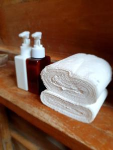 a couple of towels and a bottle of soap on a counter at Sunset Moyo Bungalows in Moyo Island