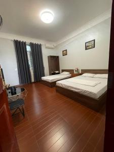 una camera d'albergo con due letti e una sedia di Hotel Me Kong 2 a Ha Long
