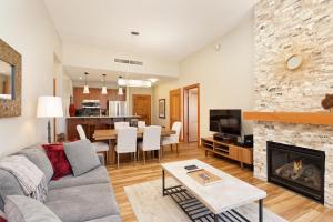 a living room with a couch and a fireplace at Slope-side Oasis Premium Snowmass Mountain Condo in Snowmass Village