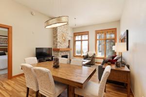 a dining room and living room with a wooden table and chairs at Slope-side Oasis Premium Snowmass Mountain Condo in Snowmass Village