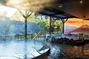 una grande piscina d'acqua con persone di Hotel Morinokaze Hakone Sengokuhara a Hakone