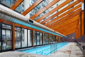 an indoor swimming pool in a building with windows at 2 Bdrm 2 Bthrm Apt With Parking in Central CBD in Melbourne