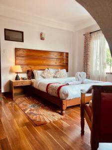 une chambre avec un grand lit avec une tête de lit en bois dans l'établissement Mount Everest Hotel & Resort Nagarkot, à Nagarkot