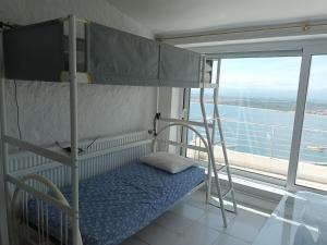 een stapelbed met een ladder in een kamer met een raam bij Casa Roses, 4 dormitorios, 7 personas - ES-258-136 in Roses