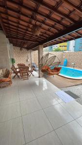 um pátio com uma piscina, uma mesa e cadeiras em Casa de Férias á 400m pra Praia de Cabo Branco em João Pessoa