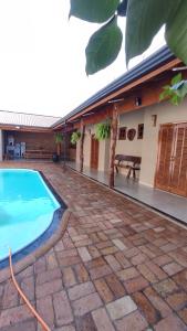 a house with a swimming pool next to a building at Recanto Dutra in Olímpia