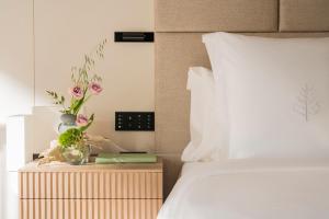 a bedroom with a bed and a night stand with flowers at Four Seasons Hotel Osaka in Osaka