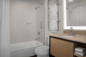 Baño blanco con aseo y lavamanos en TownePlace Suites Sacramento Cal Expo en Sacramento
