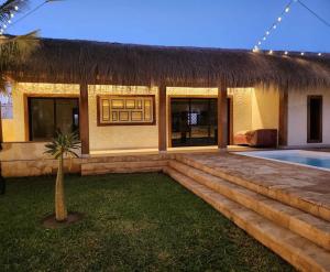 une maison avec toit de chaume et piscine dans l'établissement LE VAHINÉ Eco-RESORT, à Toliara