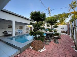 a house with a swimming pool and a garden at My Beach Villa in Port Dickson