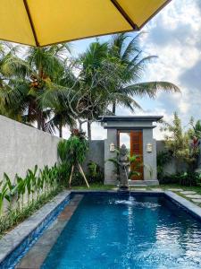 a swimming pool with a fountain in front of a house at Obah Villa Ubud 1 Br Brand new private villa in Ubud