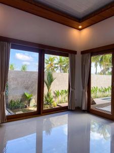an empty room with a large window and a swimming pool at Obah Villa Ubud 1 Br Brand new private villa in Ubud