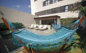 eine blaue Hängematte vor einem Gebäude in der Unterkunft Blend Coliving One - 3b in Ribeirão Preto