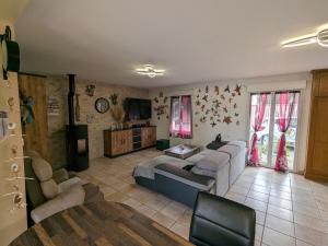 a living room with couches and a tv and a couch at Titre proposé : Gîte familial avec piscine chauffée, jardin et jeux pour enfants à l'orée de la forêt d'Orléans - FR-1-590-432 in Mareau-aux-Bois