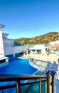 a view from the balcony of a building with a swimming pool at Loft Prainha in Arraial do Cabo