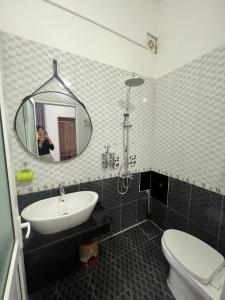 una donna che scatta una foto di un bagno con specchio di Hotel Me Kong 2 a Ha Long